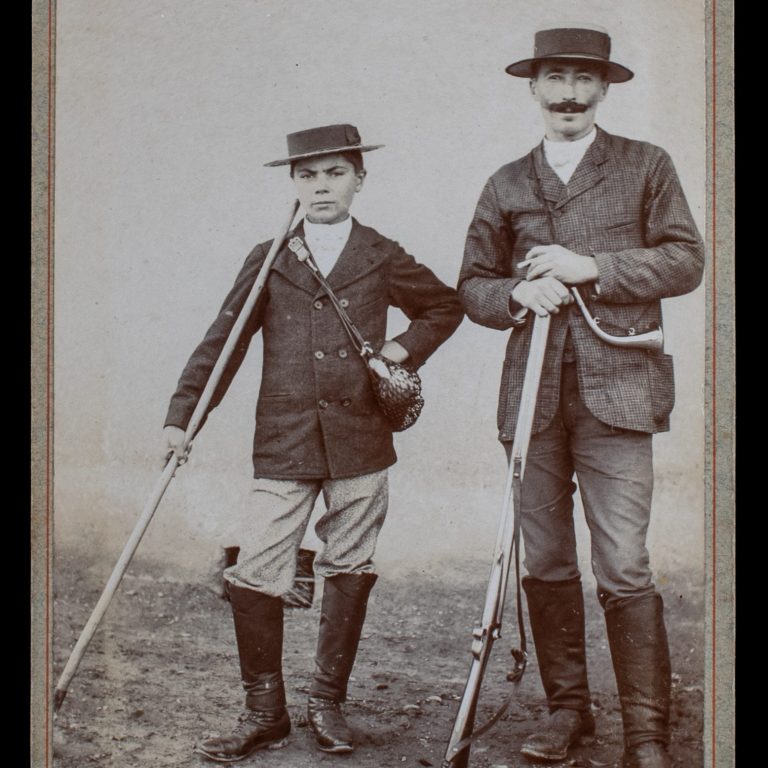 Father and Son in the Field: Sporting Companions with Shotgun and Staff